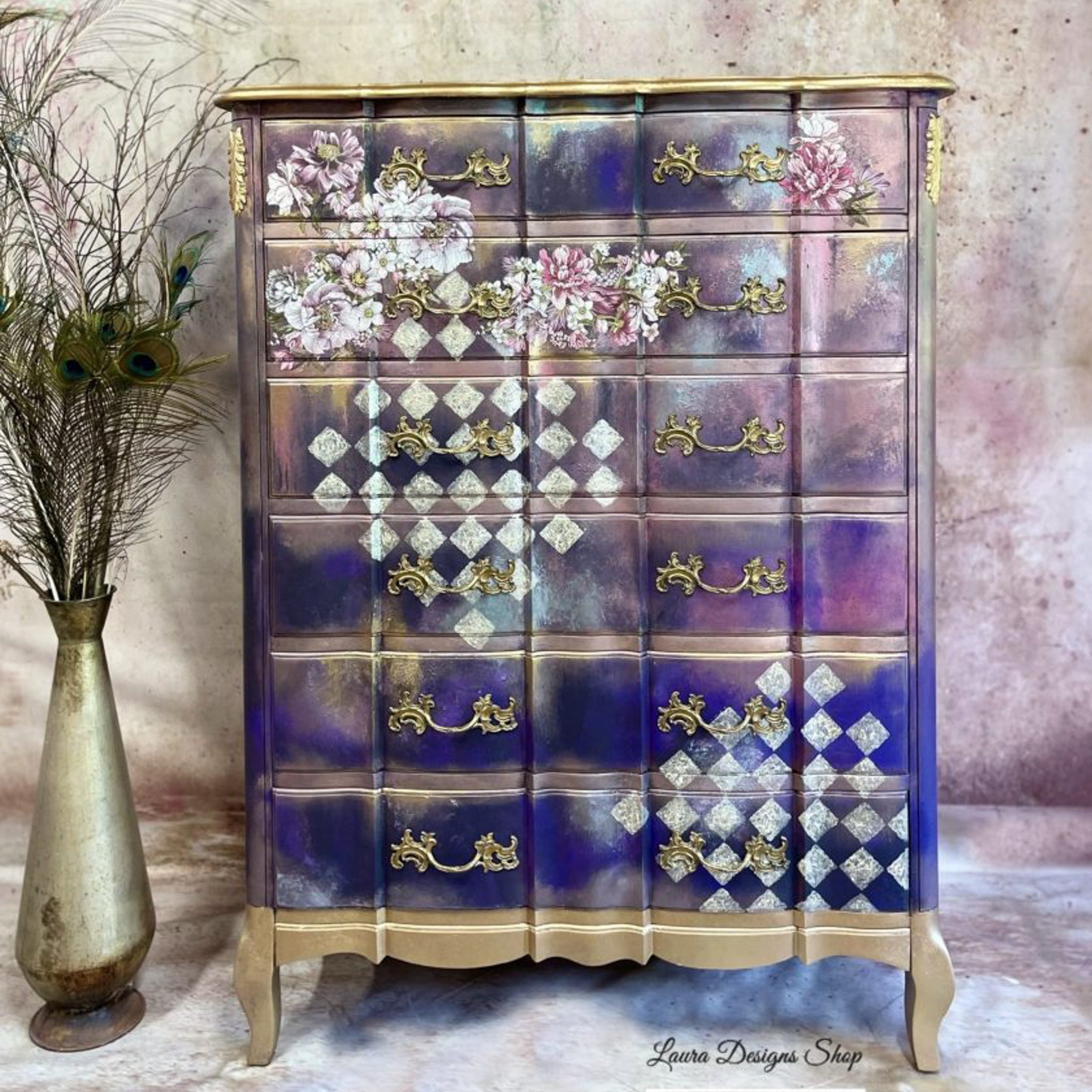 A vintage 6-drawer dresser refurbished by Laura Designs Shop is painted a blend of blue and pink with champagne gold accents and features the Dreamy Florals small transfer on its top 2 drawers.