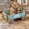 A small toy wood wagon with a teddy bear in it feaures the Farm Fresh small transfer on it.