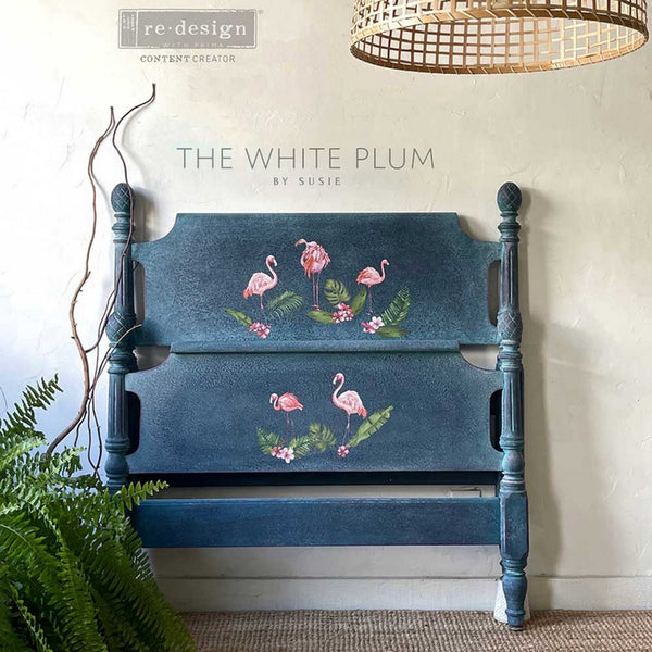 A twin headboard and footboard refurbished by The White Plum by Susie are painted blue and feature the Falimgo Pink small transfer on them.