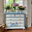 A large 5-drawer dresser is painted light blue with white drawers and features ReDesign with Prima's Mystic Hydrangea small transfer on the bottom 2 drawers.