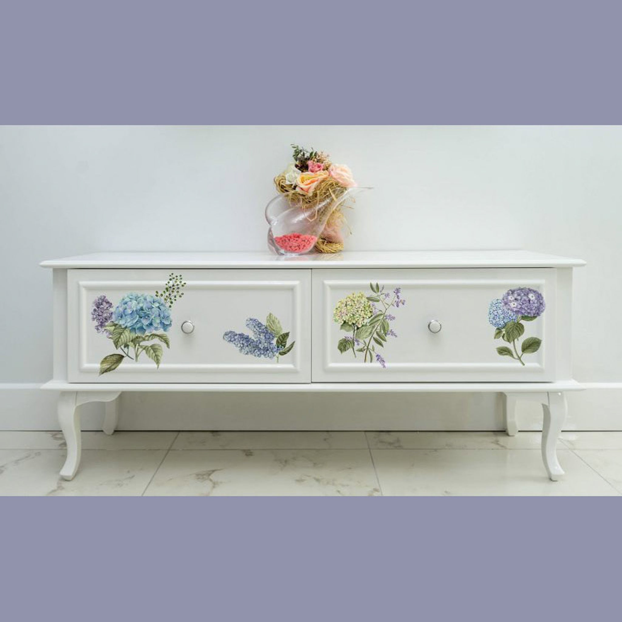 A vintage 2 drawer coffee table is painted white and features ReDesign with Prima's Mystic Hydrangea small transfer on the drawers.