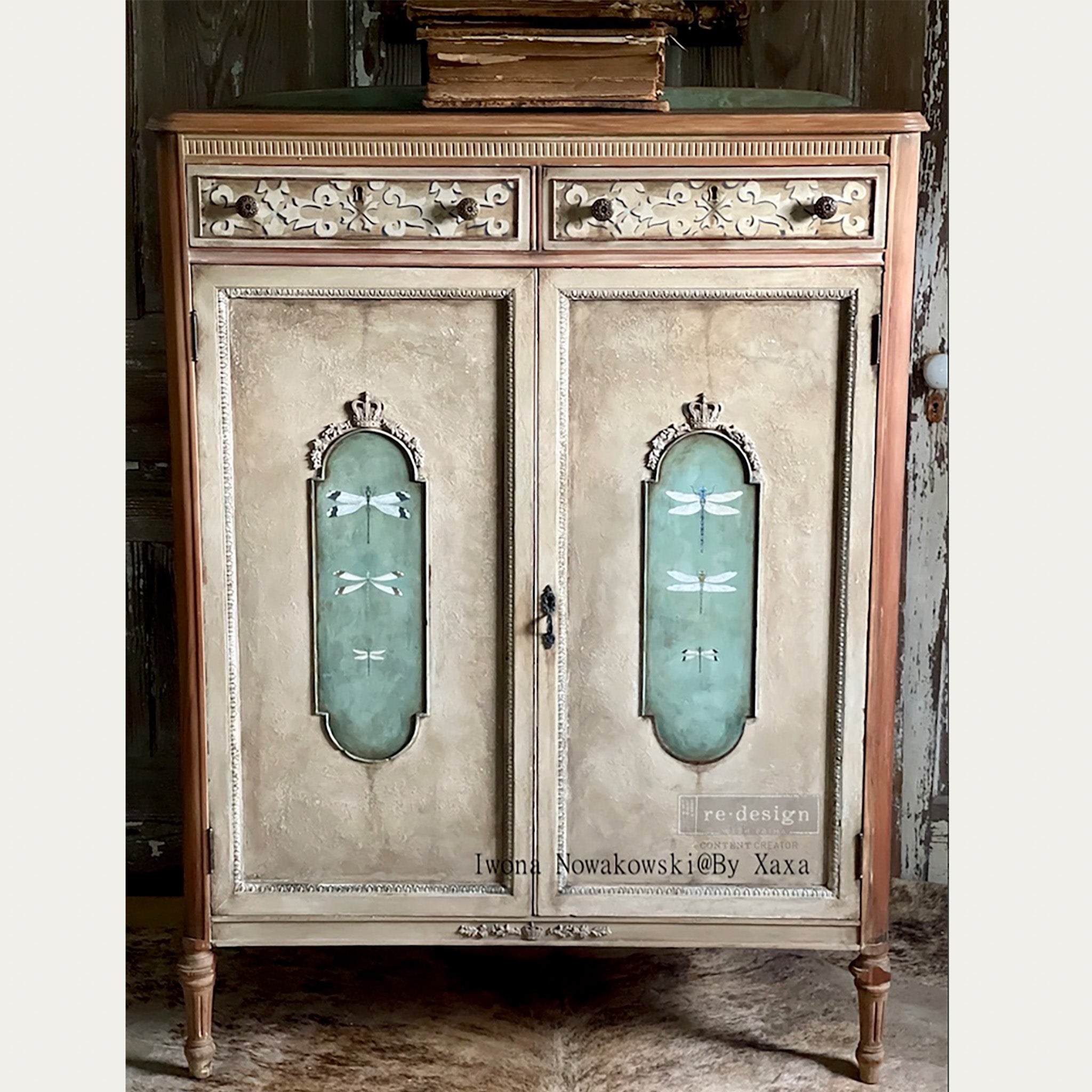 A vintage small storage cabinet refurbished by Iwona Nowakowski @ By Xaxa is painted light brown and features ReDesign with Prima's Spring Dragonfly small transfer on its door inlays.