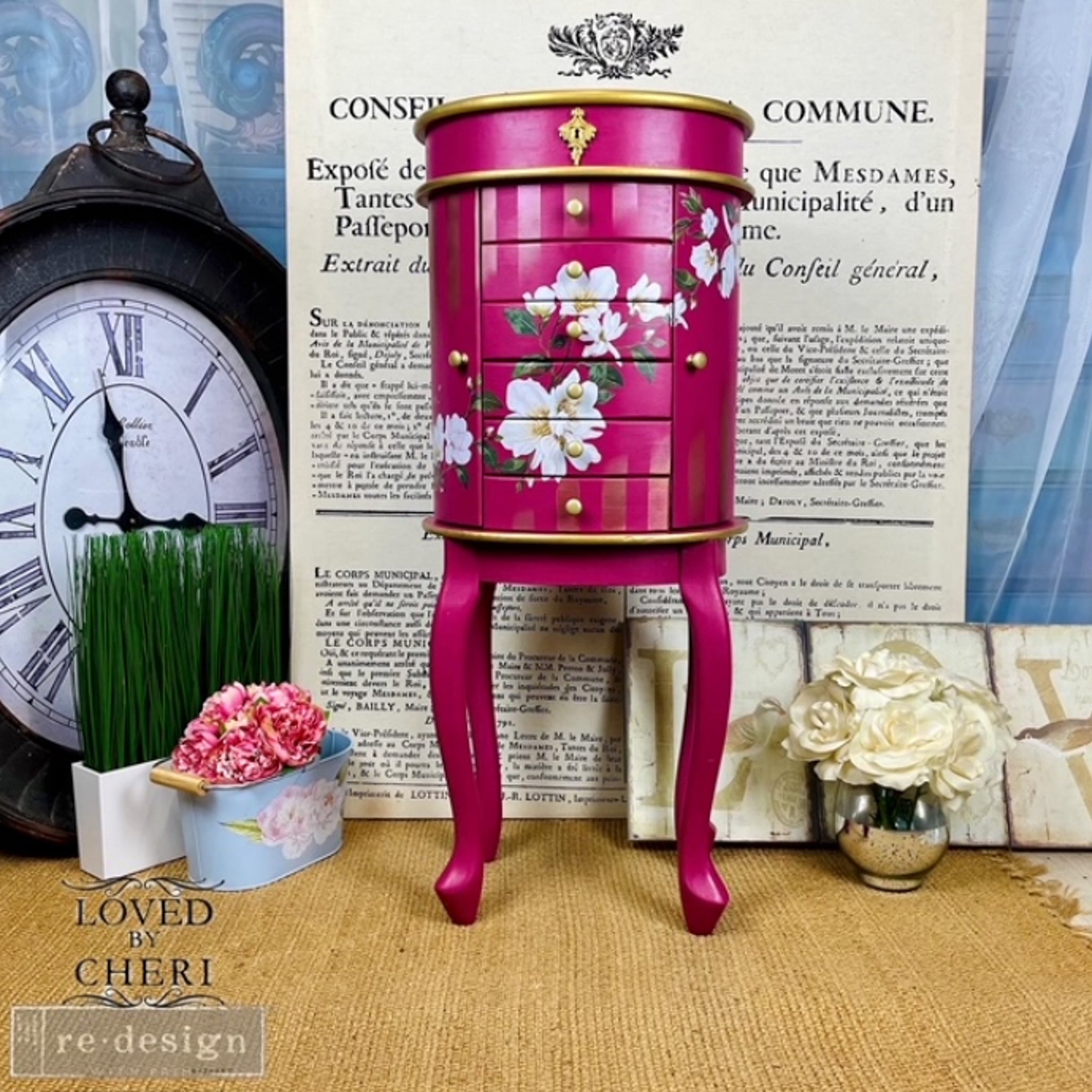 A small jewelry armoire refurbished by Loved by Cheri is painted deep pink and features ReDesign with Prima's White Magnolia small transfer on it.