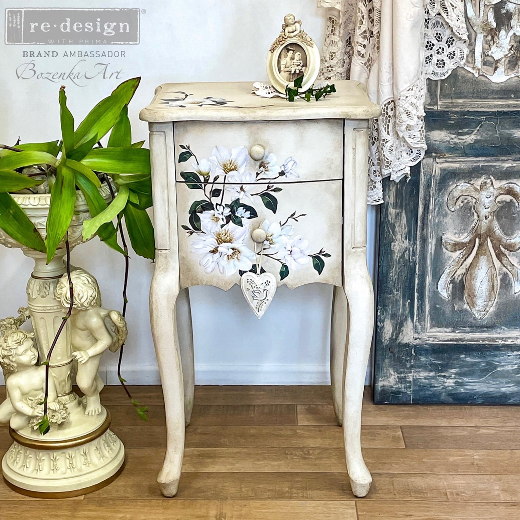 A vintage, small, 2-drawer nightstand refurbished by Bozenka Art is painted antique white and features ReDesign with Prima's White Magnolia Small transfer on it.