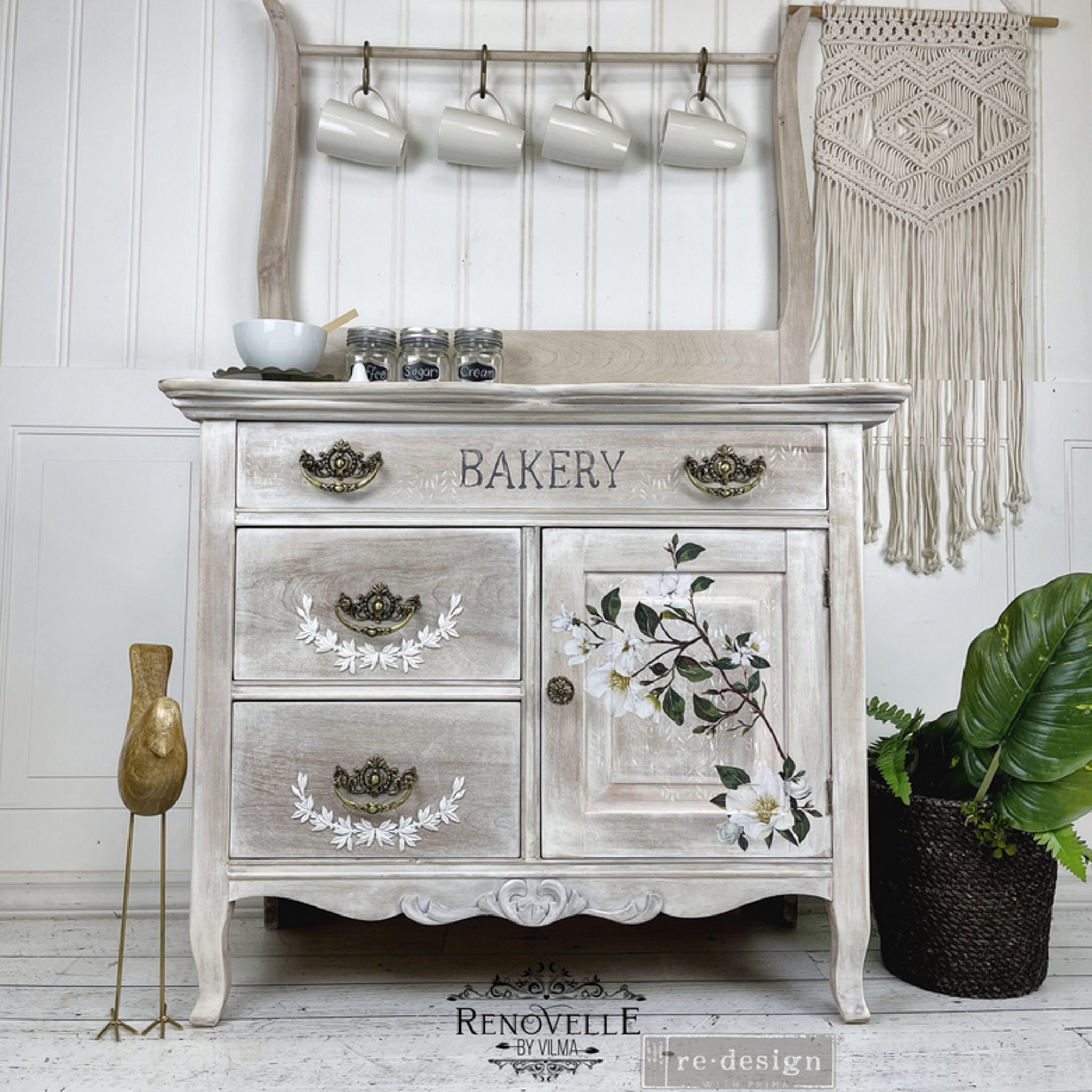 A vintage country style cabinet refurbished by Renovelle by Vilma is painted with a white-wash and features ReDesign with Prima's White Magnolia small transfer on its door.