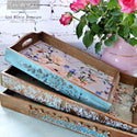 Three wood serving trays feature the Lavender Fleur tissue paper inside them.