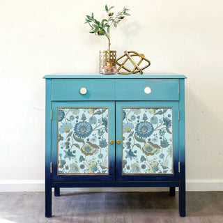 A light blue to dark blue ombre dresser with the garden waltz transfer placed on top of the drawers.