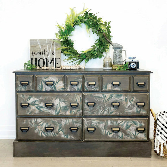 A large brown dresser with the radiant eucalyptus tissue paper design on top of the drawers.