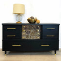 A dark blue dresser with the timeworks transfer placed on the middle drawers.