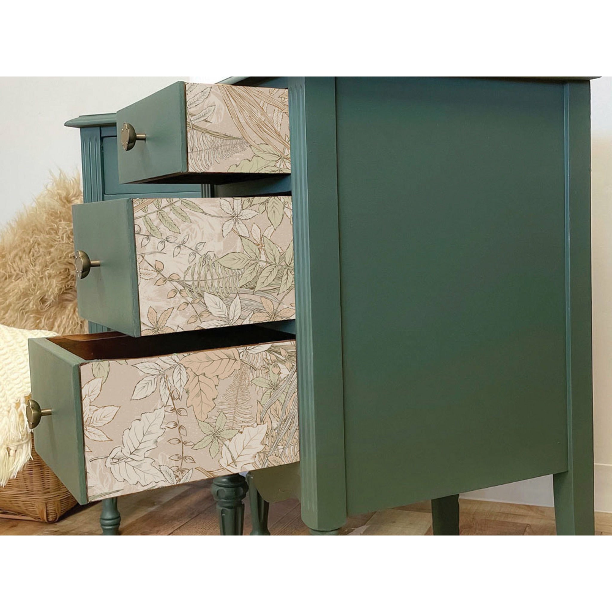 A side view of a dark muted moss green colored dresser with the drawers half way pulled out. The Tranquil Autumn tissue paper is seen placed on the side of the drawers.