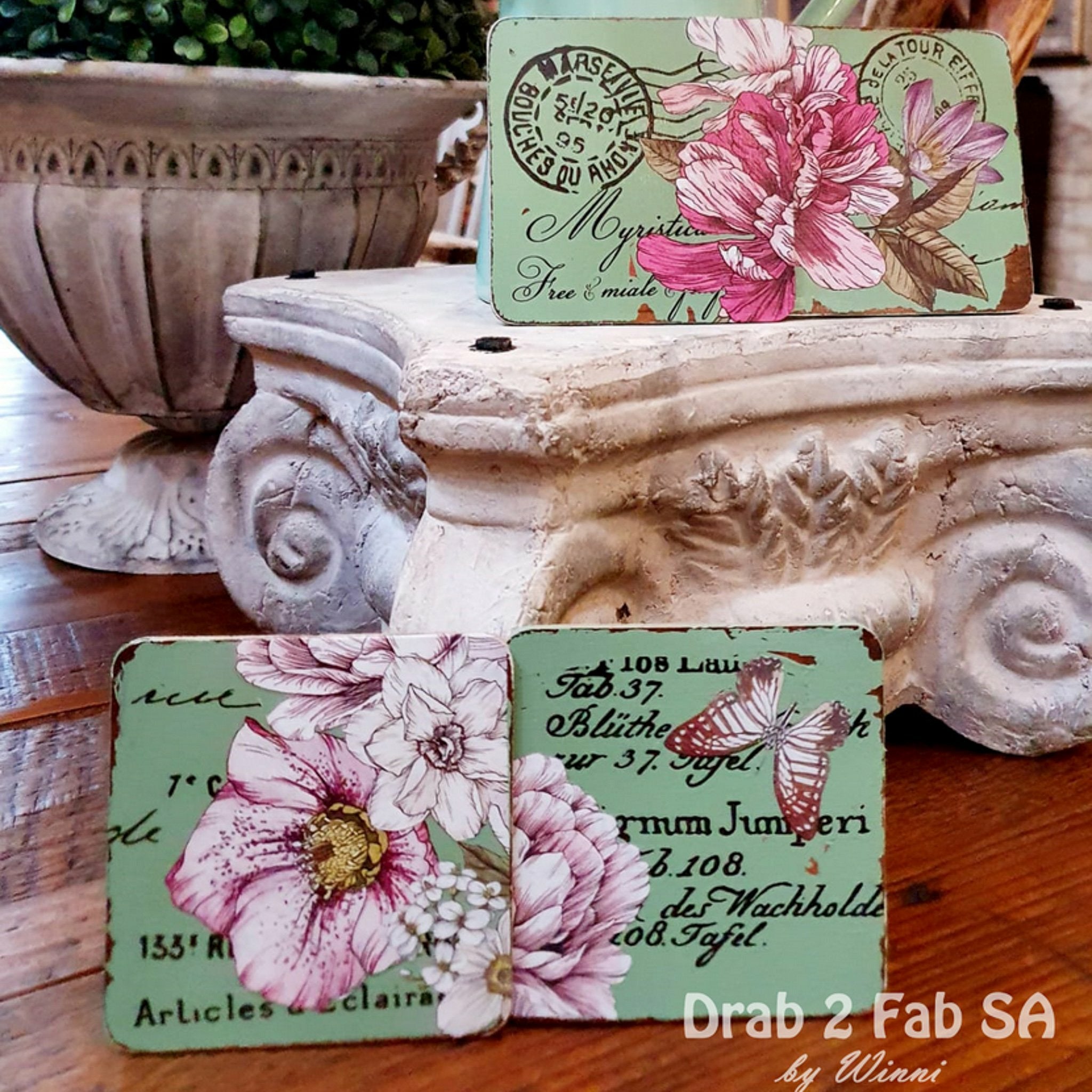 Wood coasters refurbished by Drab 2 Fab SA by Winni are painted mint green and feature the Dreamy Florals small transfer on them.