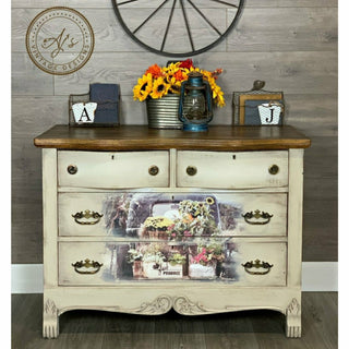 A off white dresser with the Fresh Flowers transfer on top. A brown circle Ajs Vintage Designs logo on the top left.