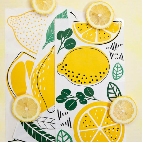 Three sheets of the lemon transfer surrounded by lemons.