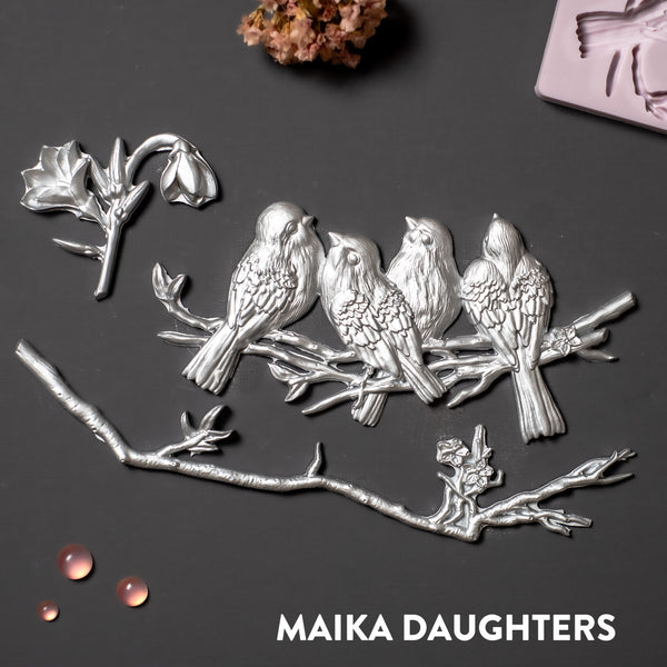 Silver silicone mold castings of small sparrow birds sitting on a branch and 2 extra branch pieces.