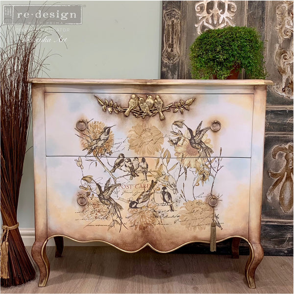 A vintage 2-drawer nightstand refurbished by Bozenka Art, a ReDesign with Prima Content Creator, is painted a blend of peach and white and features the Avian Love silicone mould on it.