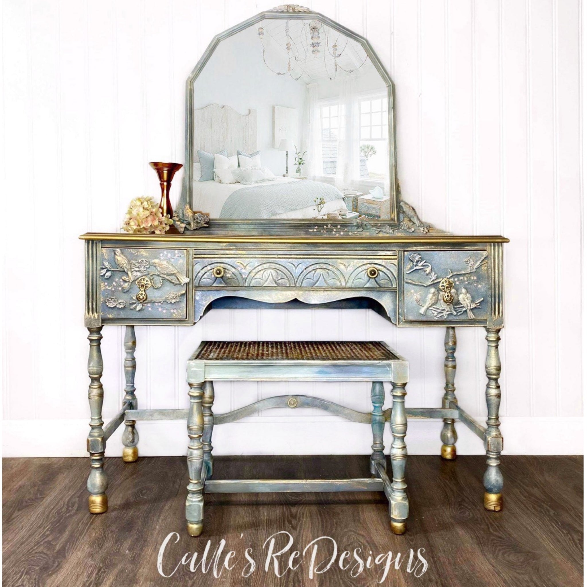 A vintage vanity refurbished by Calle's ReDesigns is painted light blue with gold accents and features the Avian Love silicone mould on it.