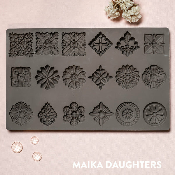 A Curio Trinkets mold tray on a pink background. A white Maika Daughters logo on the bottom right.