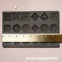 Curio Trinkets mold tray with a ruler measuring 8 in wide. A white Maika Daughters logo on the bottom right.