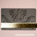 A Divine Floral mold tray with a ruler measuring 8 in wide. A white Maika Daughters logo on the bottom right.A brown silicone mould of ReDesign with Prima's Divine Floral silicone mould is on a light pink background. A gold ruler reading 8 inches sits on the mould.