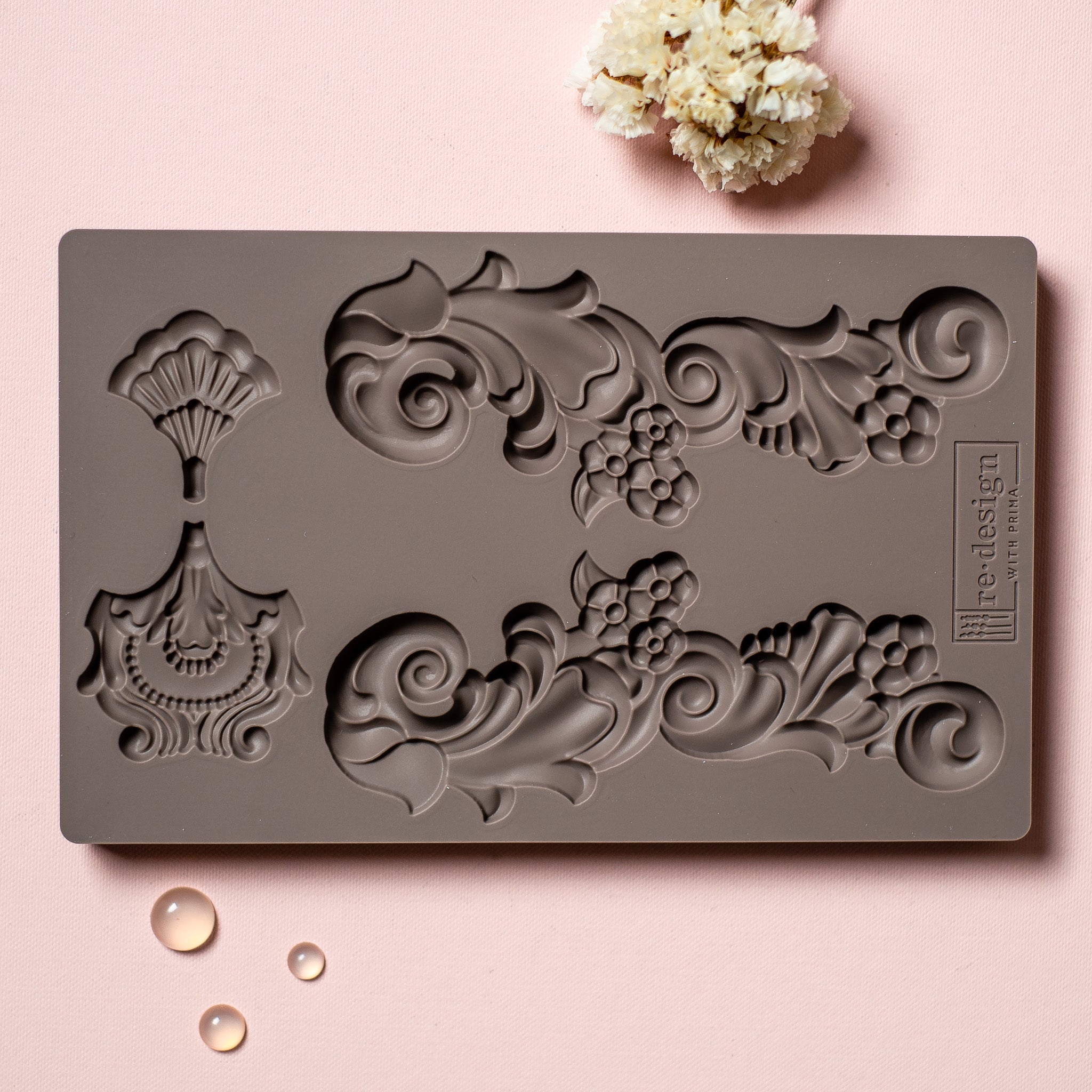 Groeneville Crest mold tray on a pink background.