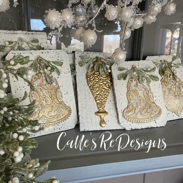 Four tiles with the silver bells mold painted in gold. A white Calles redesigns logo on the bottom.