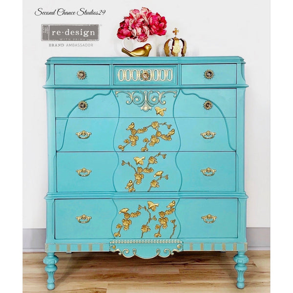 A vintage 6-drawer dresser refurbished by Second Chance Studios 29, a ReDesign with Prima Brand Ambassador, is painted sky blue and features the Aviary silicone mould in gold on it.