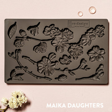 A brown silicone mould of ReDesign with Prima's Cherry Blossoms is against a light pink background.