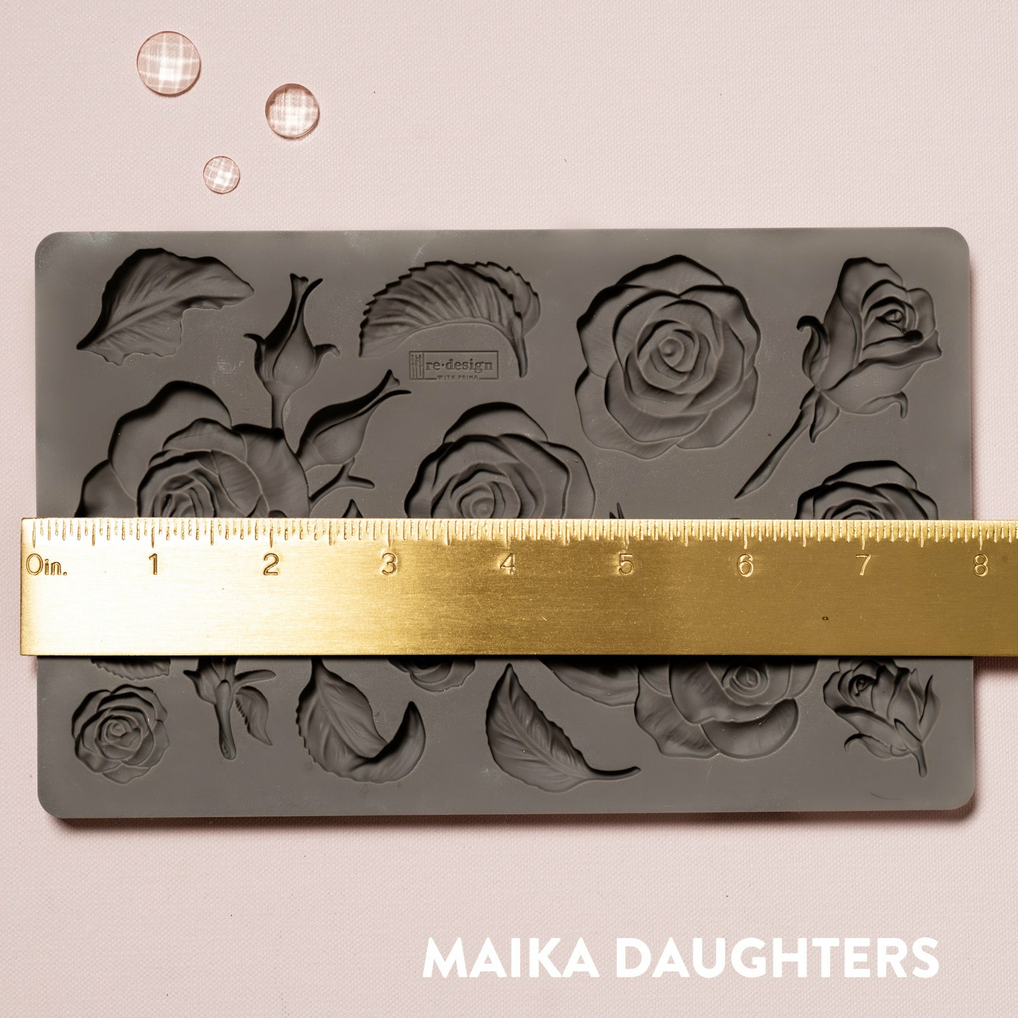 Brown silicone mould of ReDesign with Prima's Fragrant Roses is against a light pink background. A gold ruler reading 8 inches sits on the mould.