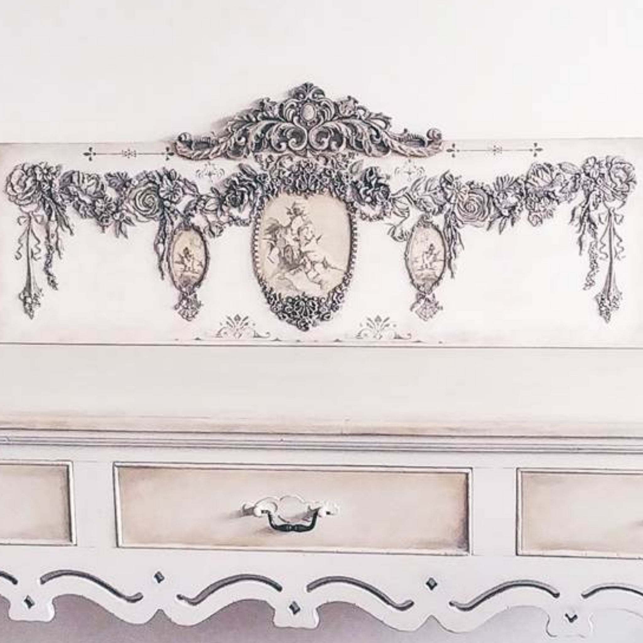 A close-up of a refurbished furniture project is painted off-white and features the Fragrant Roses silicone mould on it.