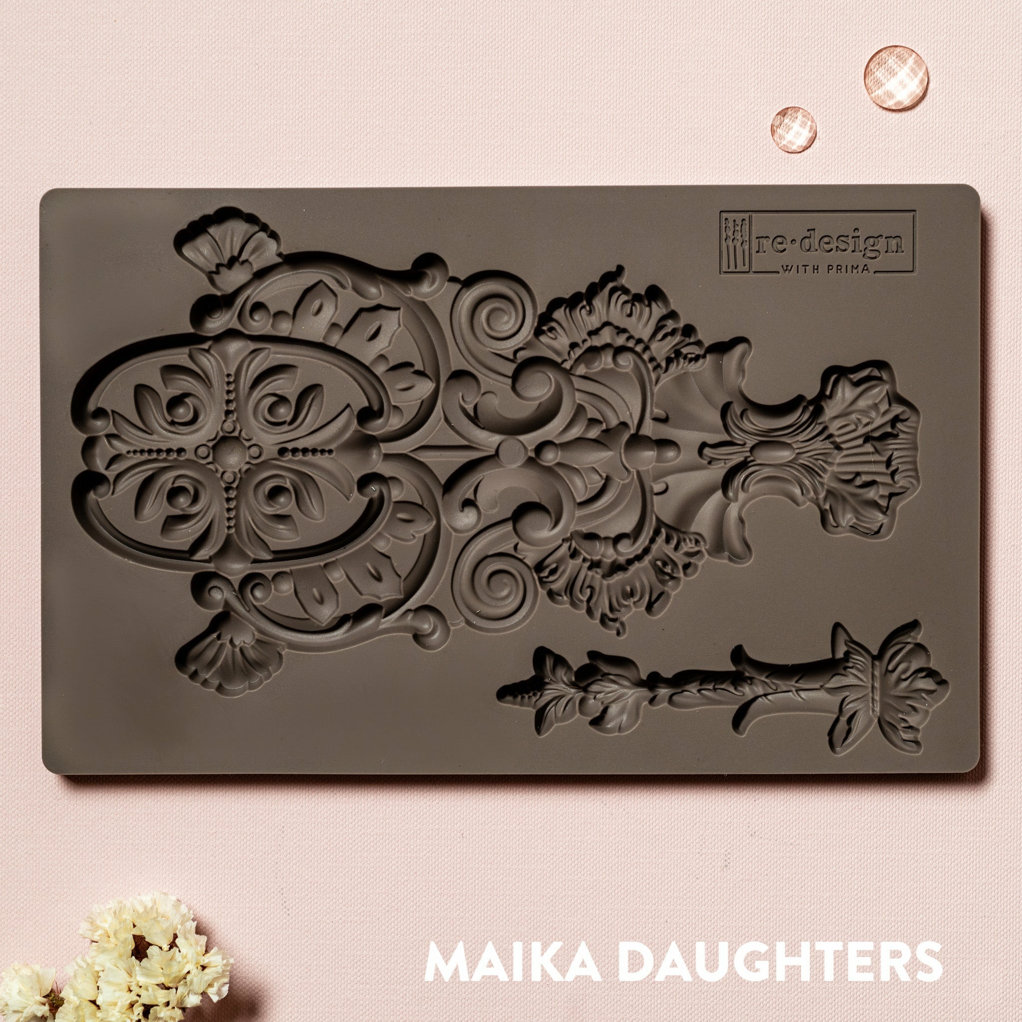 Golden Emblem mold tray on a pink background. A white Maika Daughters logo on the bottom right.