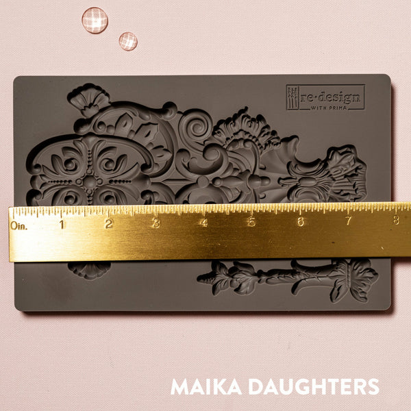 Golden Emblem mold tray with a ruler measuring 8 inches in width. A white Maika Daughters logo on the bottom right.