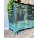 Close-up of a vintage dresser refurbishd by Leah Noell Design Co. is painted a blend of blue greens and features the Golden Emblem silicone mould castings on it.
