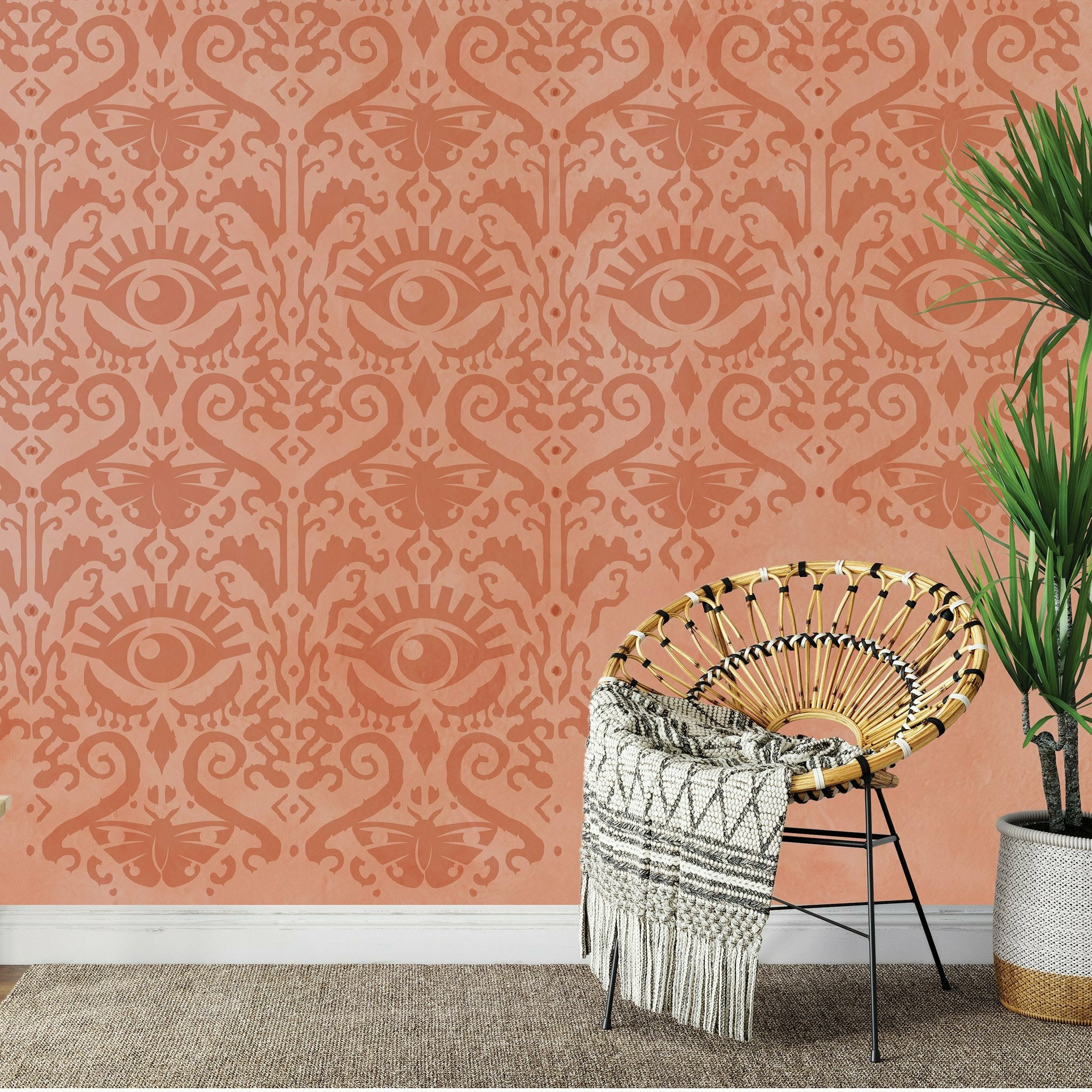 Orange wall with the All Seeing Ikat pattern wall stencil on top in a darker orange.