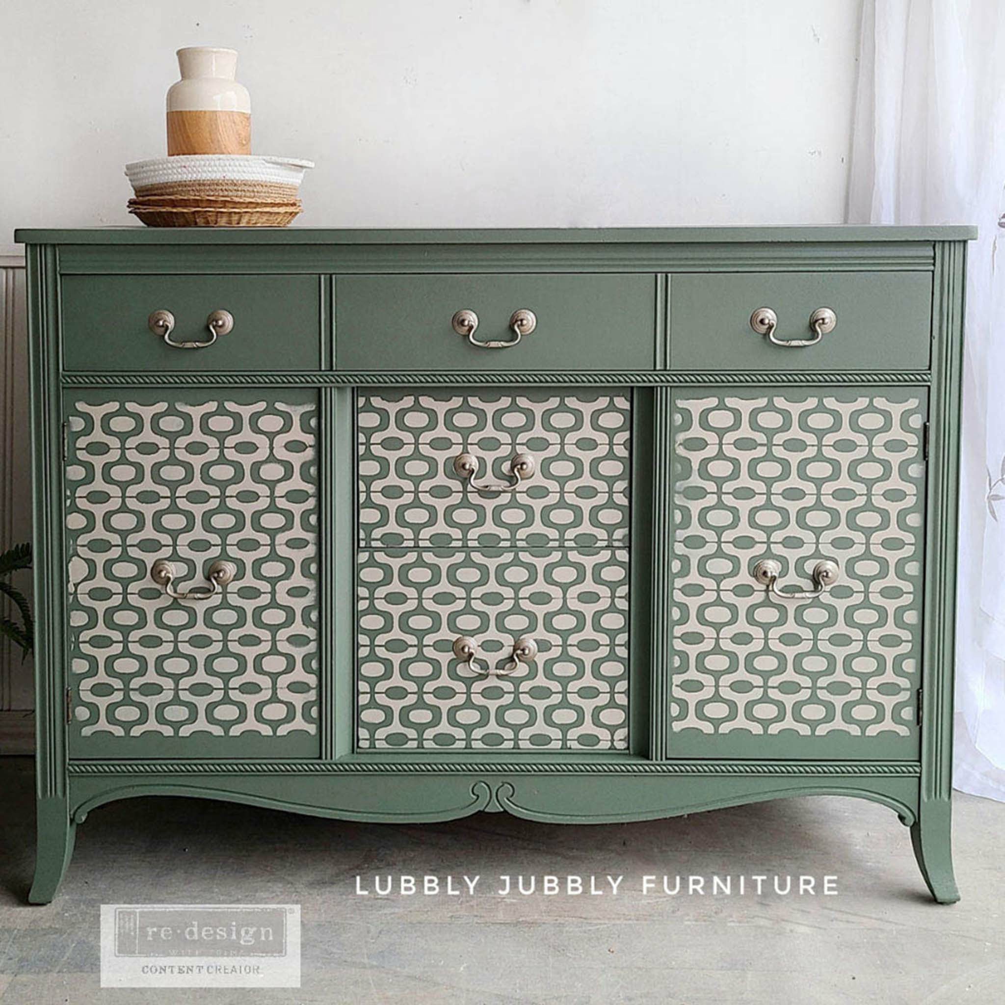 Muted green dresser with the Midcentury Vibes stencil on the front. A white Lubbly Jubbly Furniture and Redesign content creator logo on the bottom.