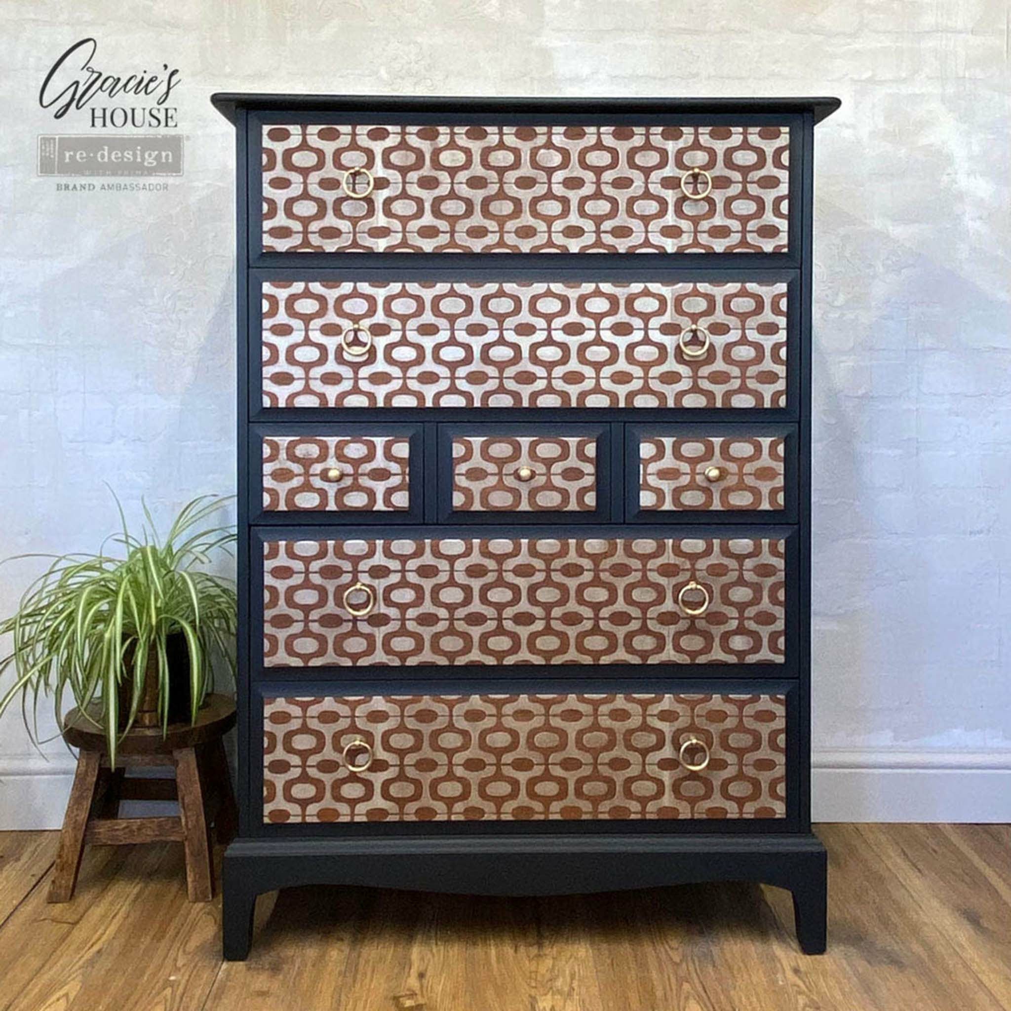 Black dresser with the Midcentury Vibes stencil on the drawers. A black Gracies house redesign brand ambassador logo on the top left.
