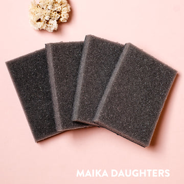 Four sanding sponges against a light pink background.