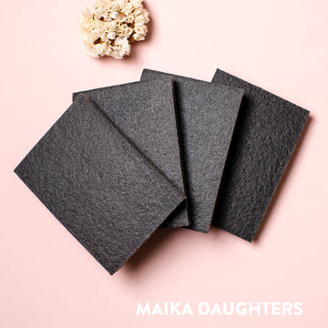 Four sanding sponges against a light pink background.