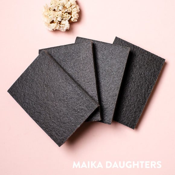 Four sanding sponges against a light pink background.