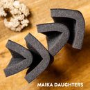 Four sanding sponges folded slightly in half against a wood table background.