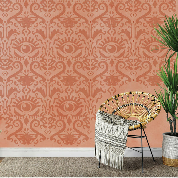 Orange wall with the All Seeing Ikat pattern wall stencil on top in a darker orange.